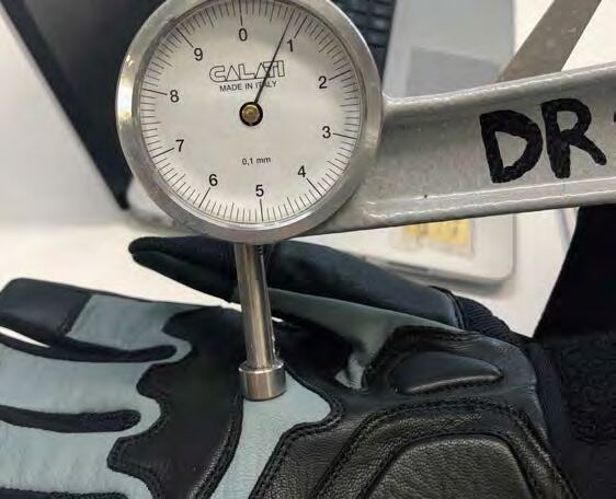 Quality control inspector measuring a glove seam with calipers